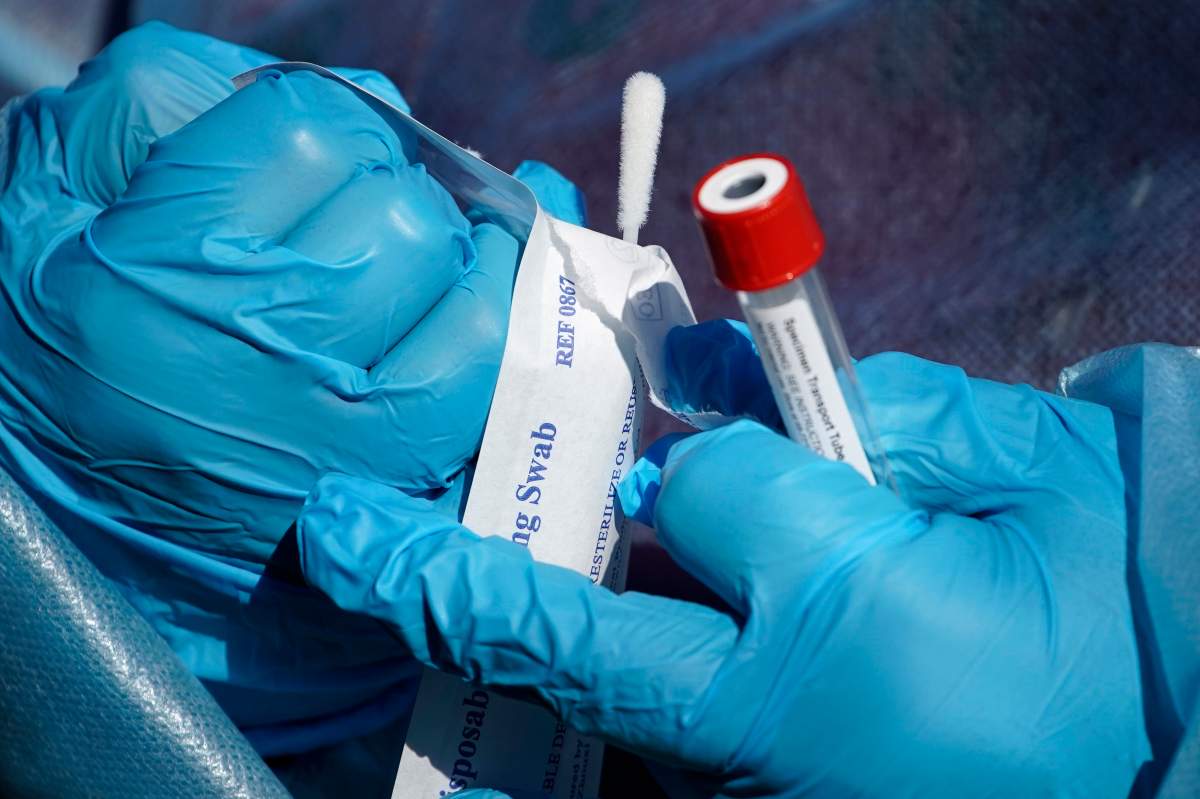 FILE - In this Thursday, Dec. 10, 2020 file photo, a registered nurse opens a swab during testing for COVID-19 in south Philadelphia.