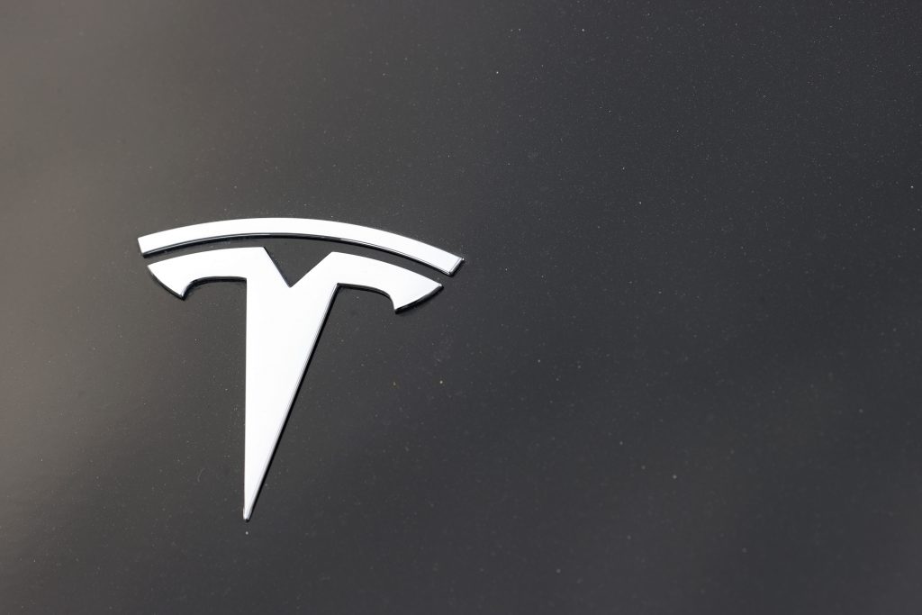 The company logo is seen on the hood of an unsold Tesla at a dealership late Sunday, Aug. 9, 2020, in Littleton, Colo.  (AP Photo/David Zalubowski).