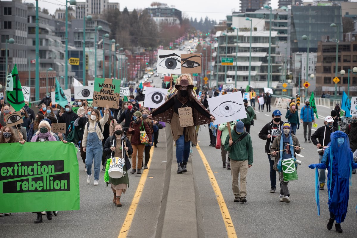 People taking part in an Extinction Rebellion protest against old-growth logging march onto the empty Cambie Bridge, in Vancouver, B.C., Saturday, March 27, 2021. 