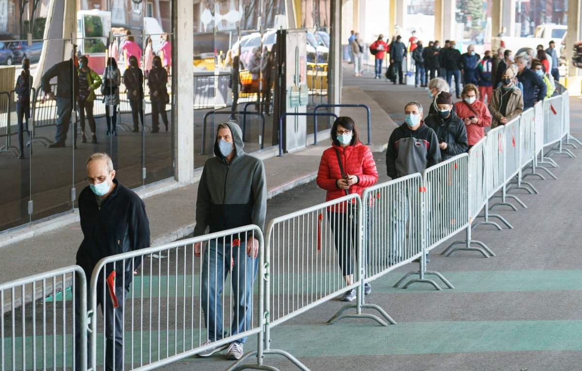 People wait in line at a COVID-19 vaccination clinic to receive the AstraZeneca vaccine at the Olympic Stadium in Montreal, on Thursday, April 8, 2021. Quebecers 55 and over can now get the AstraZeneca vaccine at walk-in clinics across the province. 