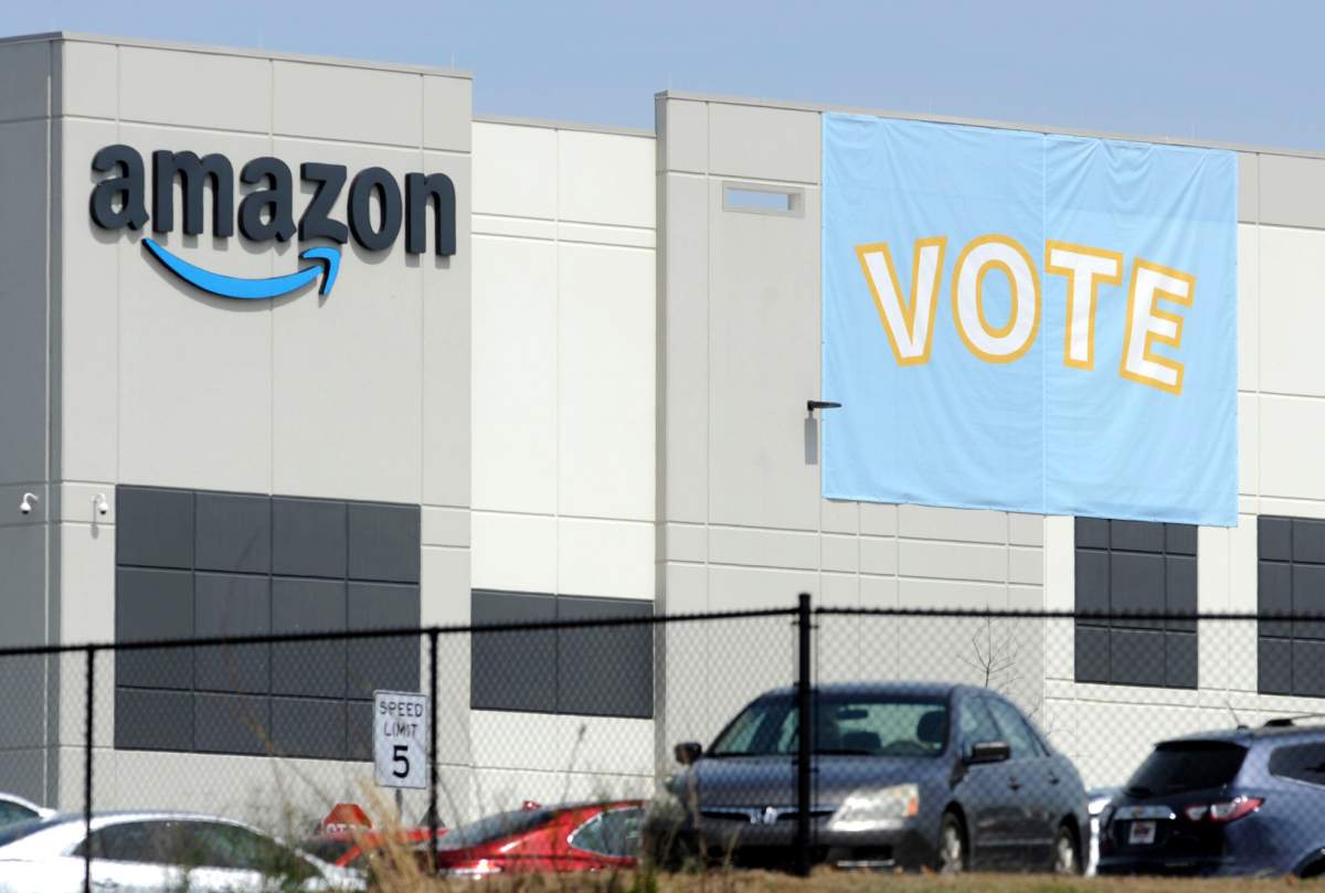 FILE - In this Tuesday, March 30, 2021 file photo, a banner encouraging workers to vote in labor balloting is shown at an Amazon warehouse in Bessemer, Ala.