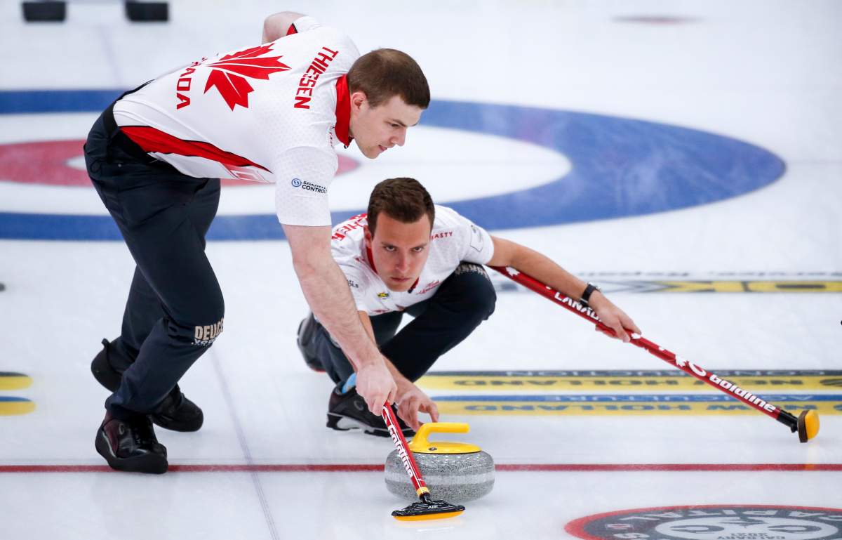 Team Canada skip Brendan Bottcher, right, makes a shot  as second Brad Thiessen sweeps against Norway at the Men's World Curling Championships in Calgary, Alta., Thursday, April 8, 2021.