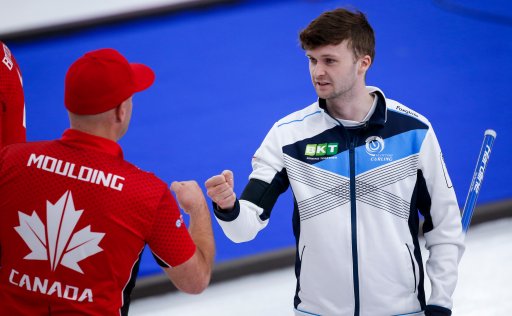 Scotland skip Bruce Mouat, right, bumps fists with Team Canada third Darren Moulding after defeating Team Canada in the qualification round at the Men’s World Curling Championships in Calgary, Alta., Friday, April 9, 2021.