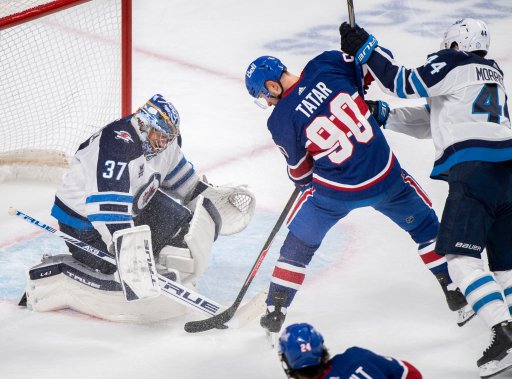 Montreal Canadiens’ Tomas Tatar (90) moves in on Winnipeg Jets goaltender Connor Hellebuyck as Jets’ Josh Morrissey defends during third period NHL hockey action in Montreal, Saturday, April 10, 2021.