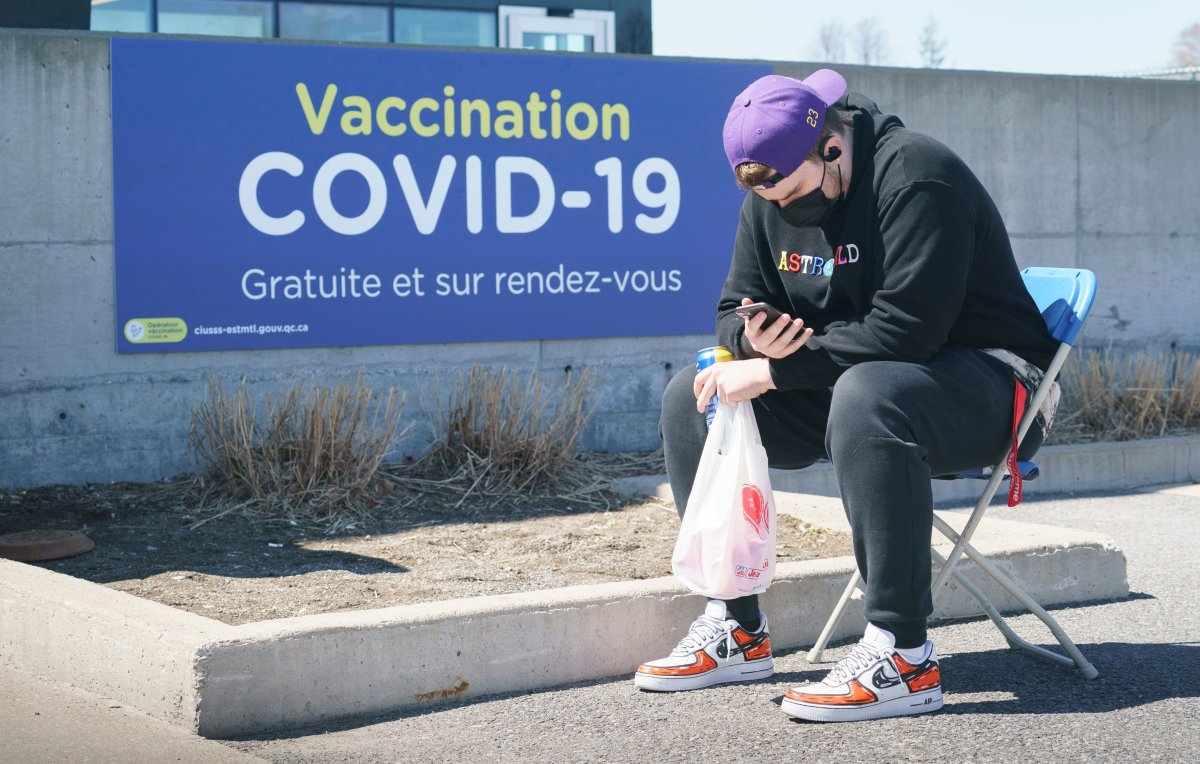 A man waits outside a COVID-19 vaccination clinic at the Martin Brodeur Arena in Montreal, on Tuesday, April 13, 2021.