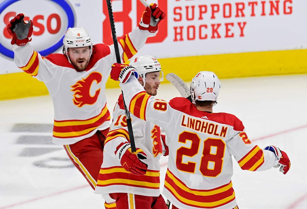 Calgary Flames’ Elias Lindholm (28) celebrates his goal against the Toronto Maple Leafs with teammates Rasmus Andersson (4) and Matthew Tkachuk (19) during second period NHL hockey action in Toronto on Tuesday, April 13, 2021.