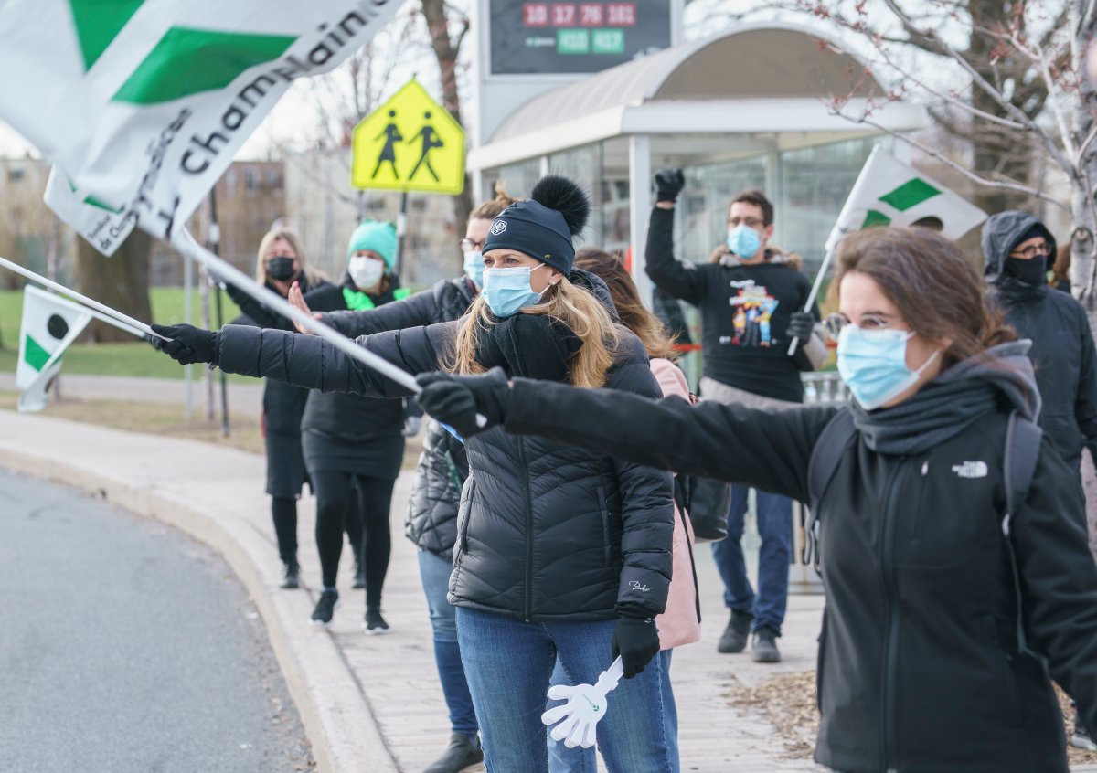 Teachers demonstrate outside a school during a morning walk-out in Longueuil, Que. on Wednesday, April 14, 2021. Teachers are striking to express dissatisfaction with negotiations with the Quebec government that have gone on for more than a year.