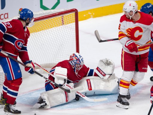 Montreal Canadiens goaltender Jake Allen (34) makes a save as Calgary Flames’ Matthew Tkachuk, right, and Montreal Canadiens Alexander Romanov, left, look on during second period NHL hockey action Wednesday, April 14, 2021 in Montreal.