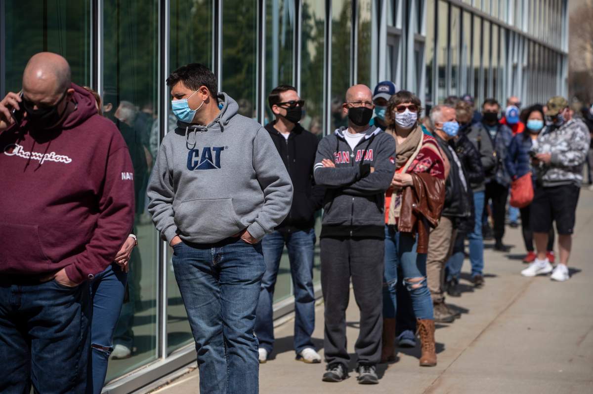 People line up outside an immunization clinic to get their Oxford-AstraZeneca COVID-19 vaccine in Edmonton on Tuesday, April 20, 2021.