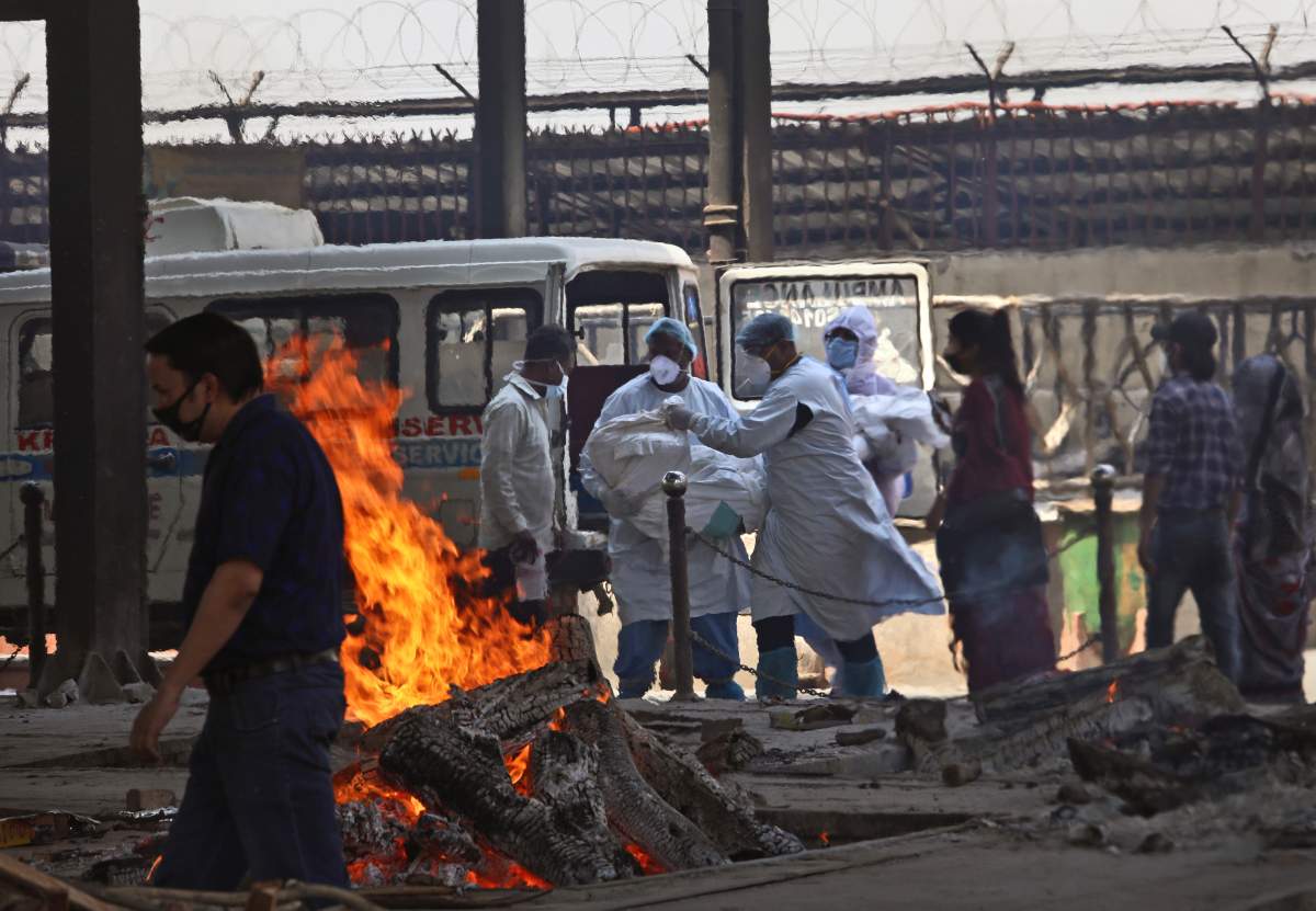 Health workers carry a body of a COVID-19 victim for cremation, in New Delhi, India, Monday, April 19, 2021. (AP Photo/Manish Swarup)