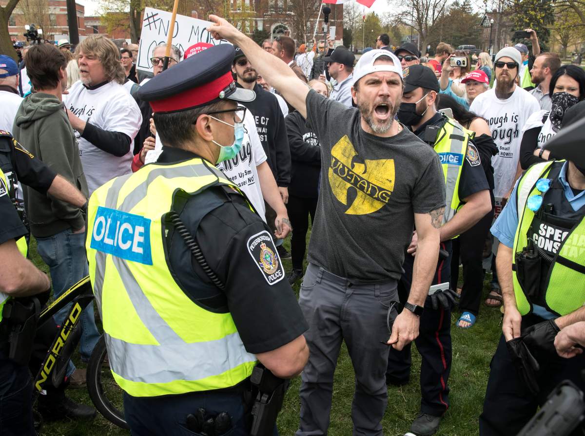 A demonstrator argues with police at a protest against government measures to curb the spread of COVID-19, in Peterborough, Ont., on April 24, 2021. THE CANADIAN PRESS/Fred Thornhill