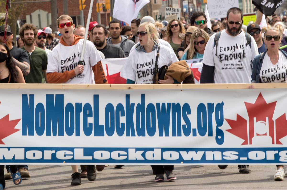Demonstrators march at a protest against government measures to curb the spread of COVID-19, in Peterborough, Ont., on April 24, 2021. THE CANADIAN PRESS/Fred Thornhill