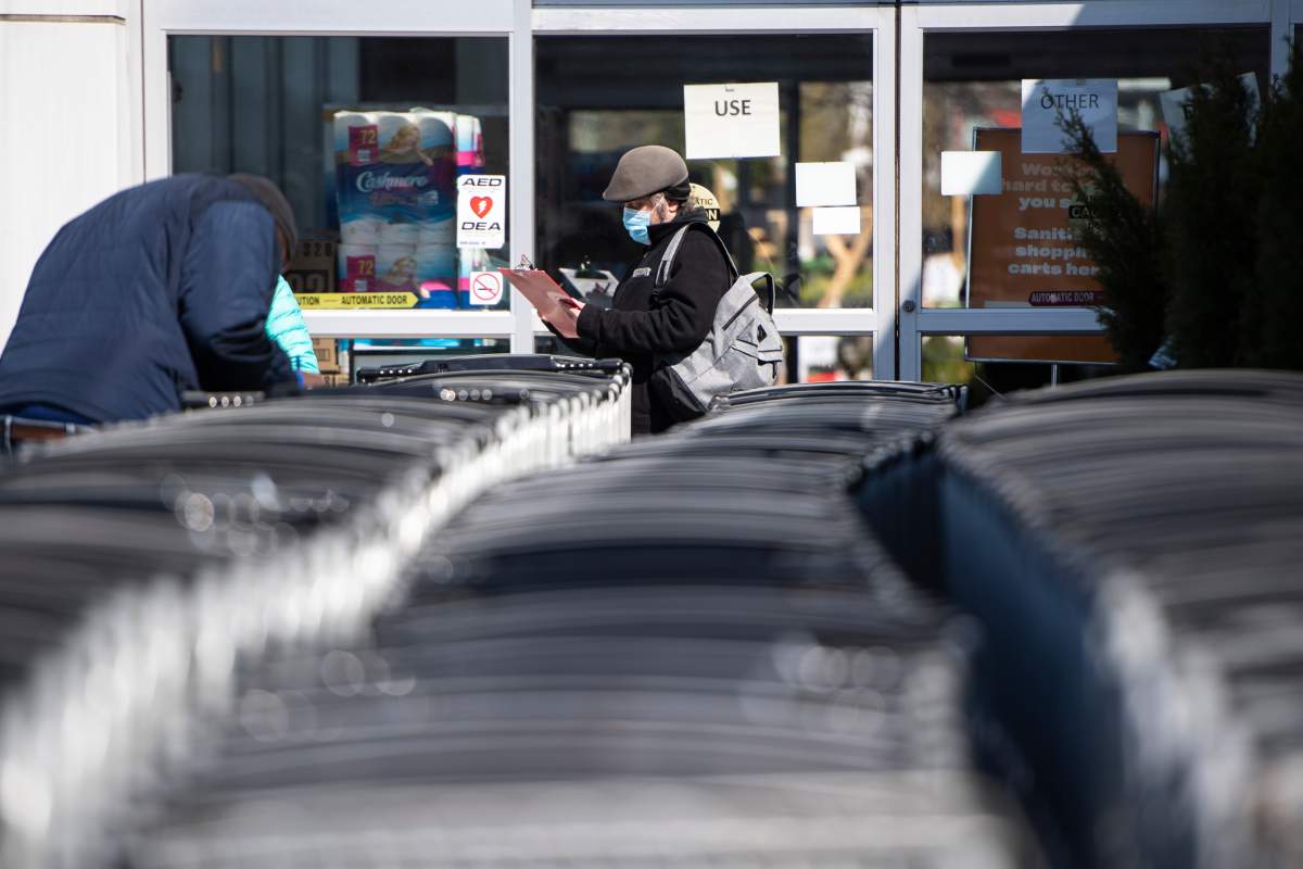 People fill out paperwork as they line up to receive a COVID-19 vaccine at a Loblaws grocery store pharmacy in Ottawa, on Monday, April 26, 2021.