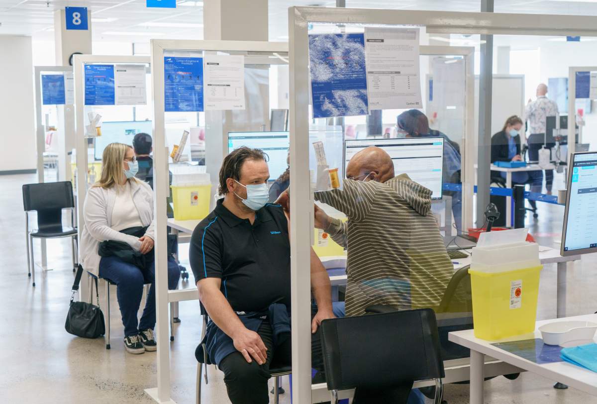 Employees are vaccinated at a COVID-19 vaccination clinic at CAE headquarters in Montreal, on Monday, April 26, 2021. A provincial program to provide vaccinations at large businesses began today at the Montreal headquarters of the flight simulation technology manufacturer.