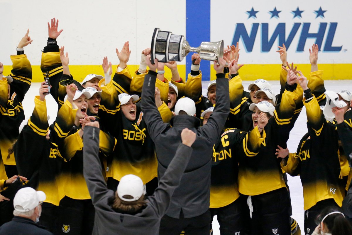 Boston Pride players cheer as coach Paul Mara hoists the NWHL Isobel Cup trophy after the team's win over the Minnesota Whitecaps in the championship hockey game in Boston, in this Saturday, March 27, 2021, file photo. The National Women’s Hockey League made a potentially game-changing decision for the sport in approving to double its salary cap to $300,000 for each of its six teams on Wednesday, April 28, 2021.