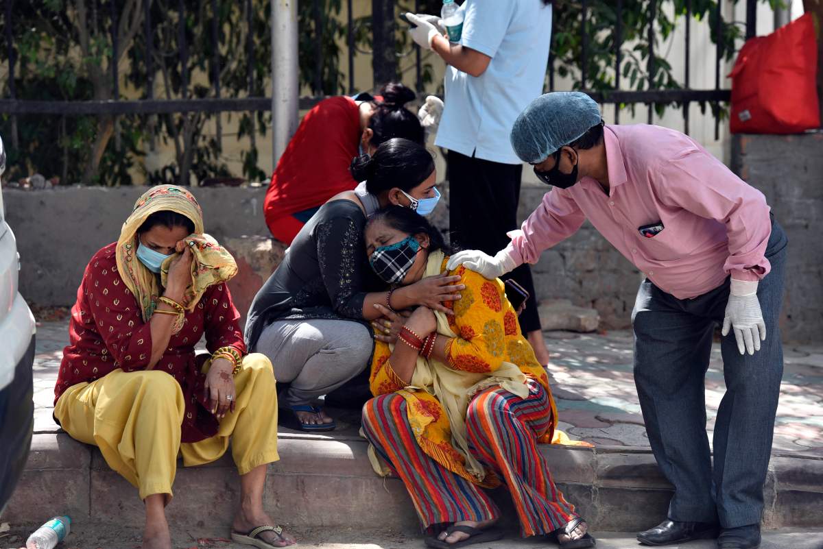 Grieving relatives and family members of COVID-19 victims wait outside Maulana Azad Medical College mortuary to collect their bodies, on April 25, 2021, in New Delhi, India.