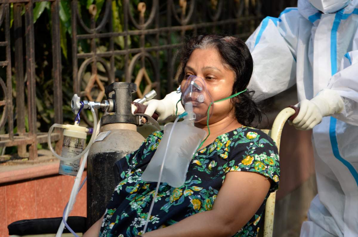 A COVID-19 patient in a wheelchair goes for a medical test inside a government hospital in Kolkata, India, April 27, 2021.