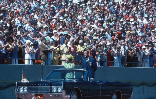 Queen Elizabeth ll and Prince Philip, Duke of Edinburgh ride in an open car past spectators in the stands as they arrive to open the Commonwealth Games on Aug. 3, 1978, in Edmonton, Canada.
