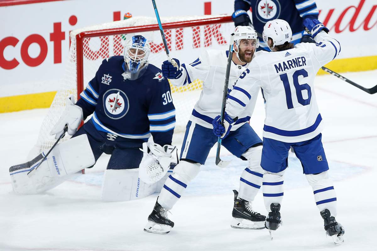 Toronto Maple Leafs' Nick Foligno (71) and Mitchell Marner (16) celebrate Marner's goal on Winnipeg Jets goaltender Laurent Brossoit (30) during second period NHL action in Winnipeg on Thursday, April 22, 2021. 