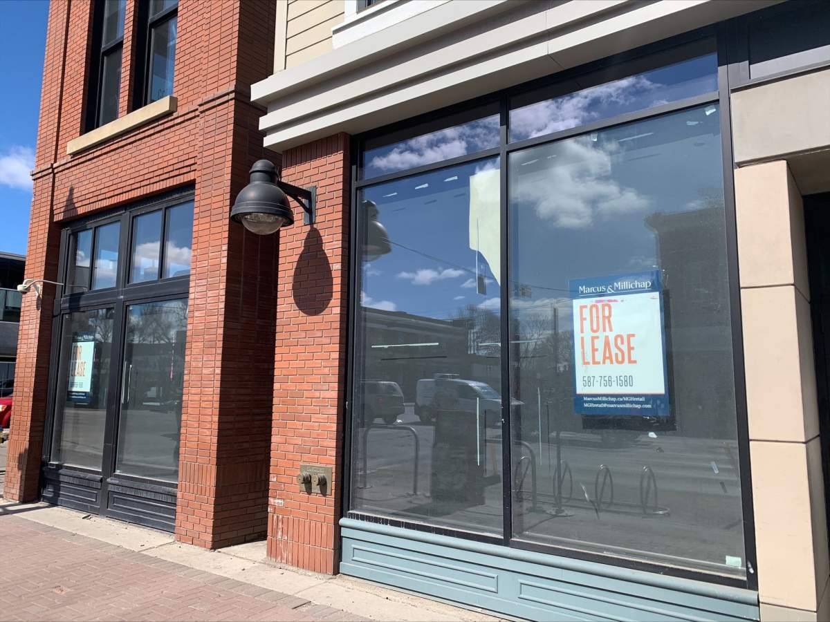 An empty storefront shows for lease signs in the window on Whyte Avenue and 104 Street.