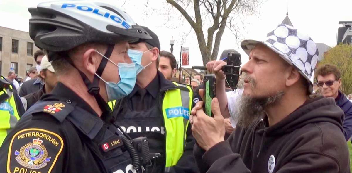 Peterborough Police Service Chief Scott Gilbert faces a man during an anti-lockdown protest at Confederation Square in 2021.