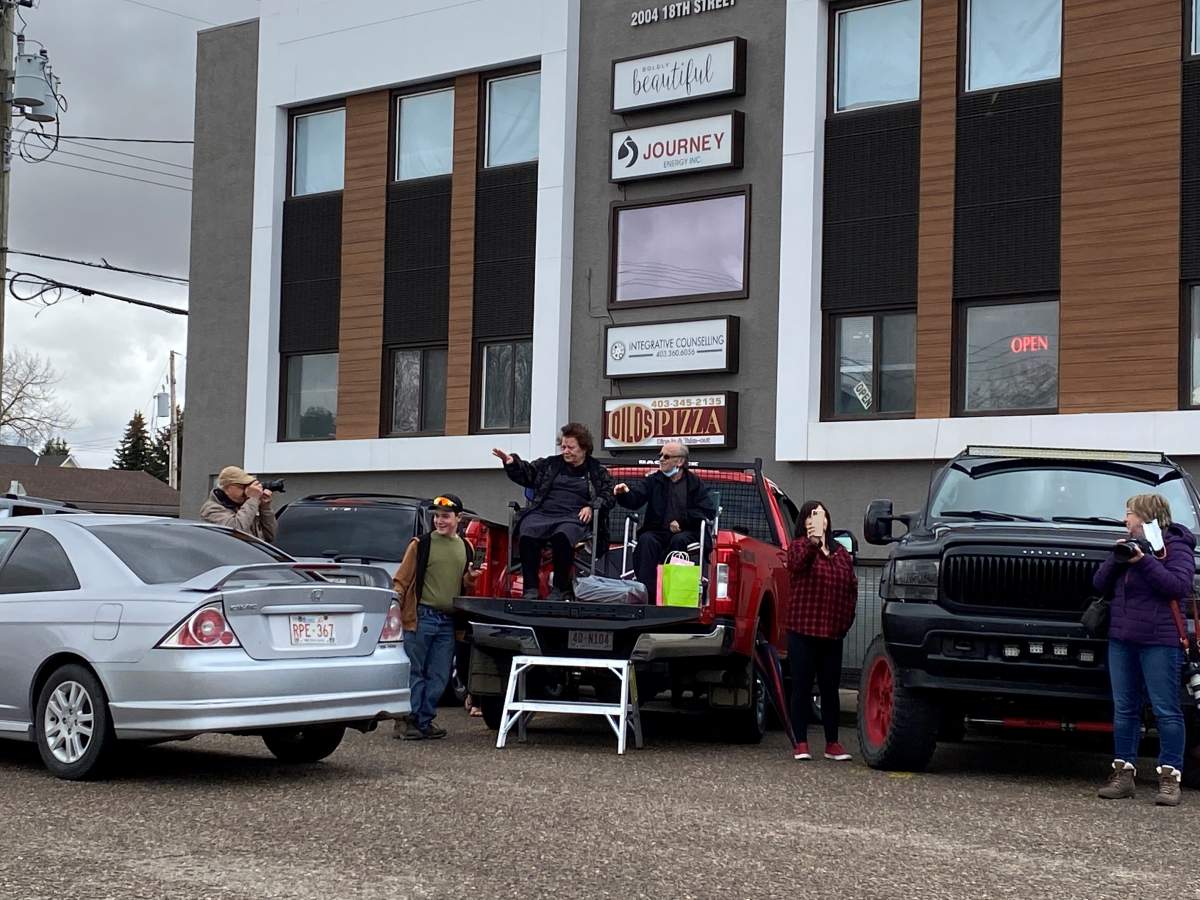 The Kollias family waves to cars as they drive by the restaurant on their final day of business.