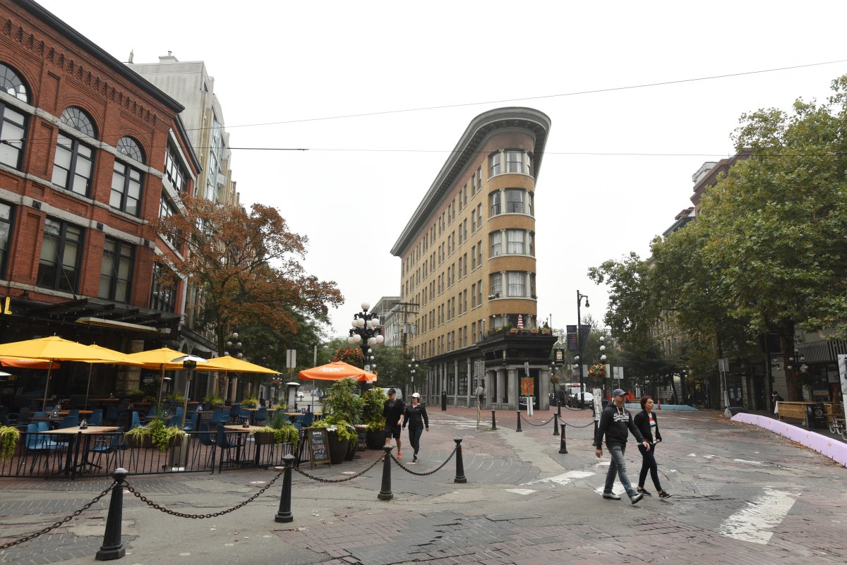 Pedestrians walk through Maple Tree Square in the historic Gastown shopping and restaurant district in Vancouver, British Columbia on September 18, 2020.  