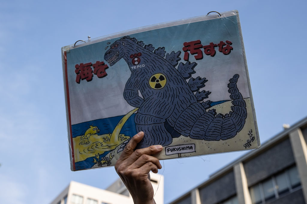 A man holds a placard during a demonstration outside of the Prime Minister’s official residence on April 12, 2021, in Tokyo, Japan.