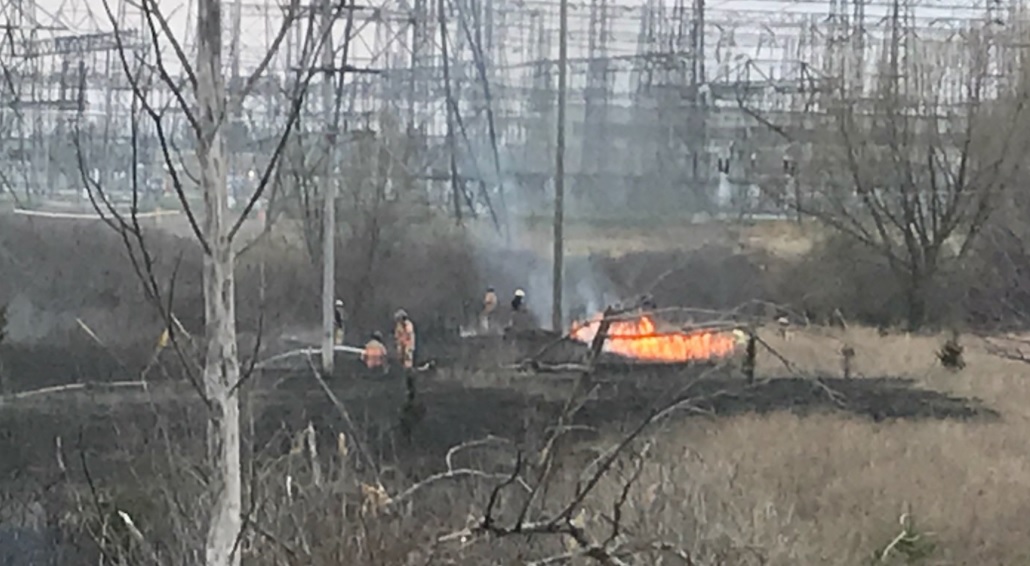 Several London fire department crews are battling a “stubborn” grass fire at Highway 401 and Highbury Avenue Thursday evening.