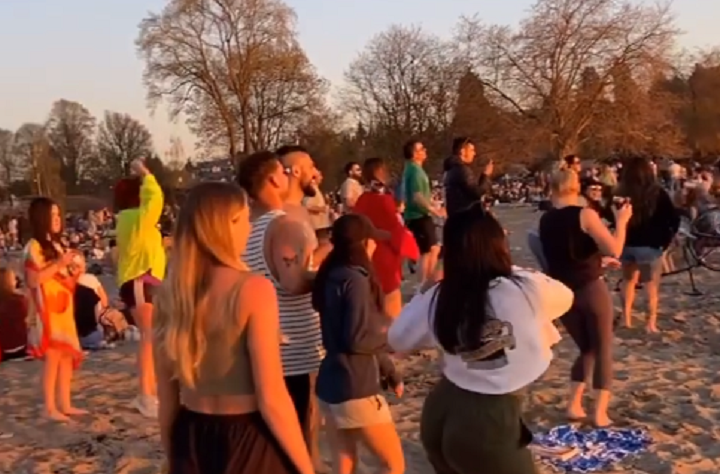 Still images from video posted to Instagram shows people, some of them without masks, dancing in groups on Vancouver’s Kits Beach.