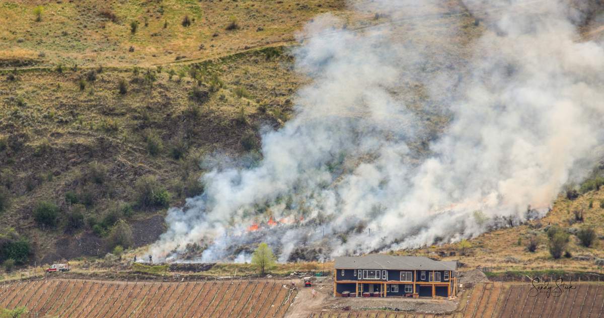 The Oliver Fire Department said Tuesday's grass fire was burning about 100 metres from a residence. 