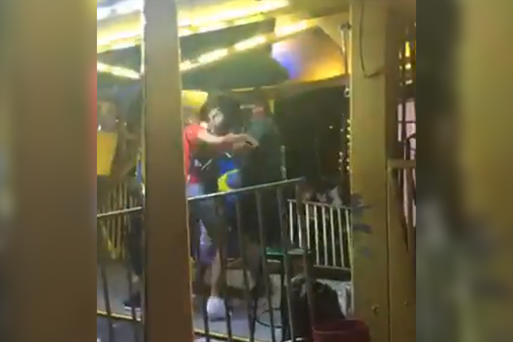A ferris wheel operator and a woman trade blows during a dispute in Opa Locka, Fla., in this image from a Facebook Live video on April 17, 2021.