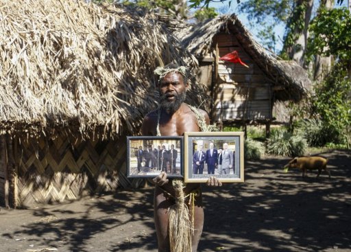 In this Sunday, May 31, 2015 file photo, Albi Nagia poses with photographs of Prince Philip in Yakel, Tanna island, Vanuatu.