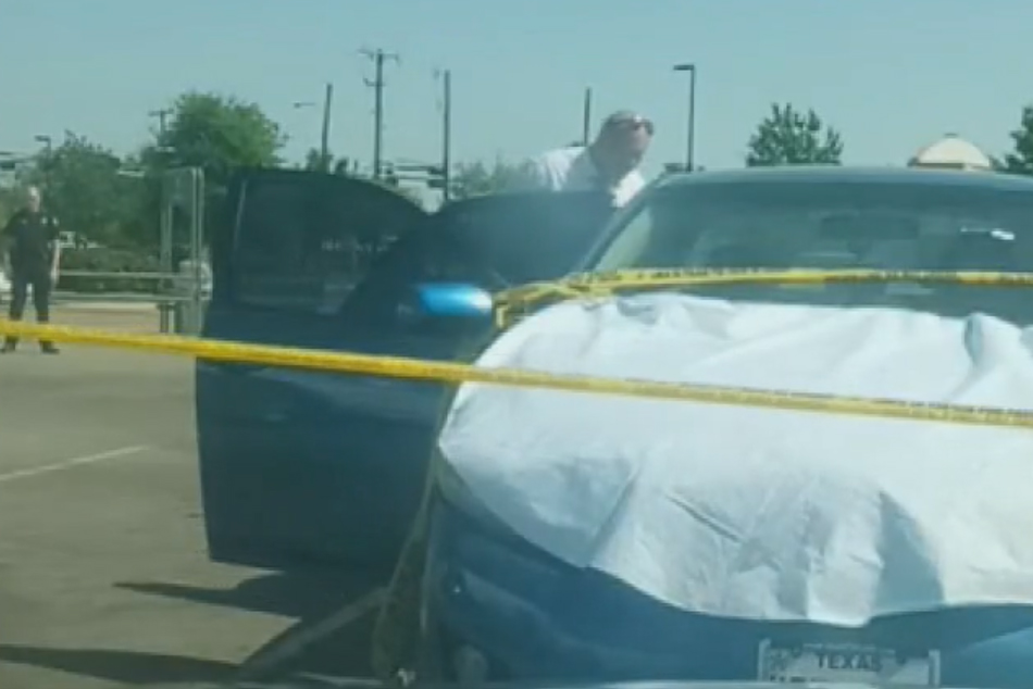 Police investigate a car where a boy, 11, was fatally shot outside a Walmart in Dallas, Texas, on Apr. 11, 2021.