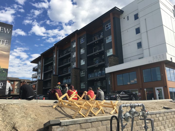 People sit outside an evacuated apartment building in West Kelowna on Sunday morning. 
