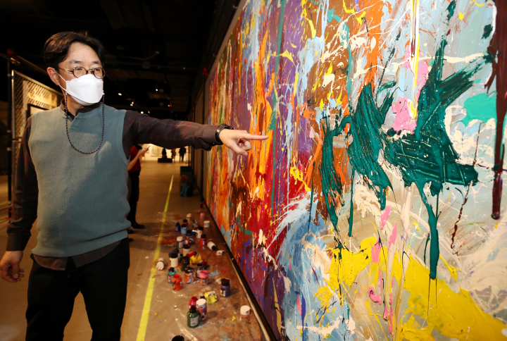 Kang Wook, head of the STREET NOISE exhibition at the Lotte World Mall, points to damage on an untitled JonOne artwork on March 28, 2021.