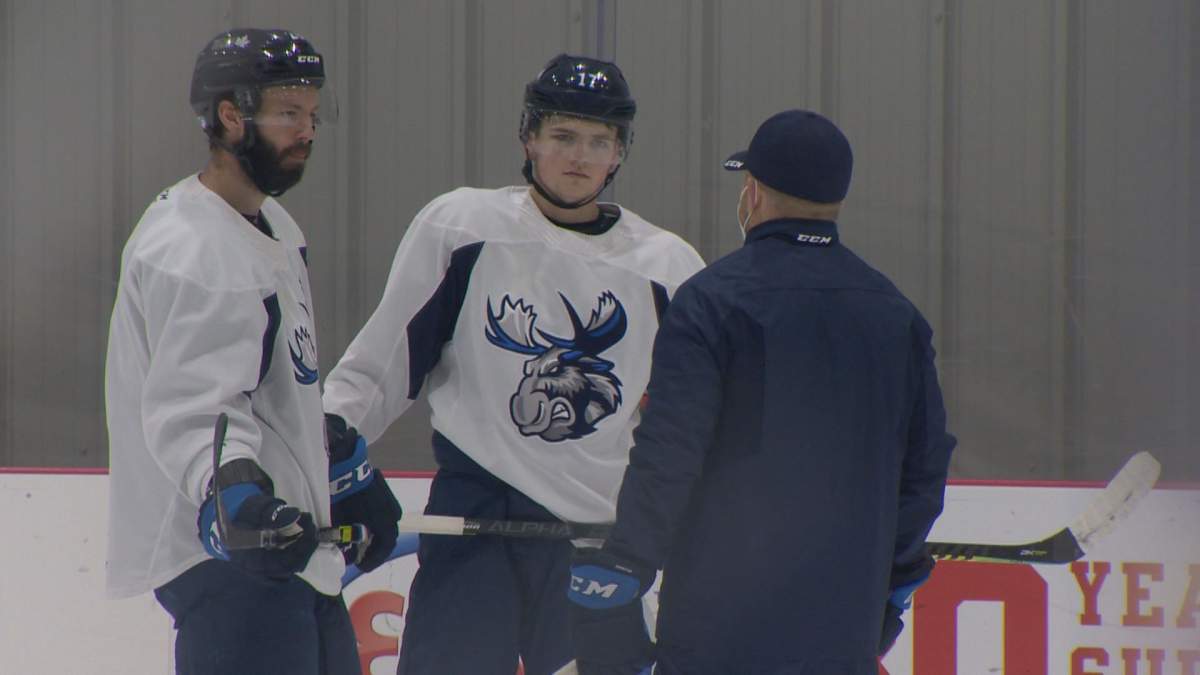Manitoba Moose forward Cole Perfetti talking to a coach at a team practise in April.
