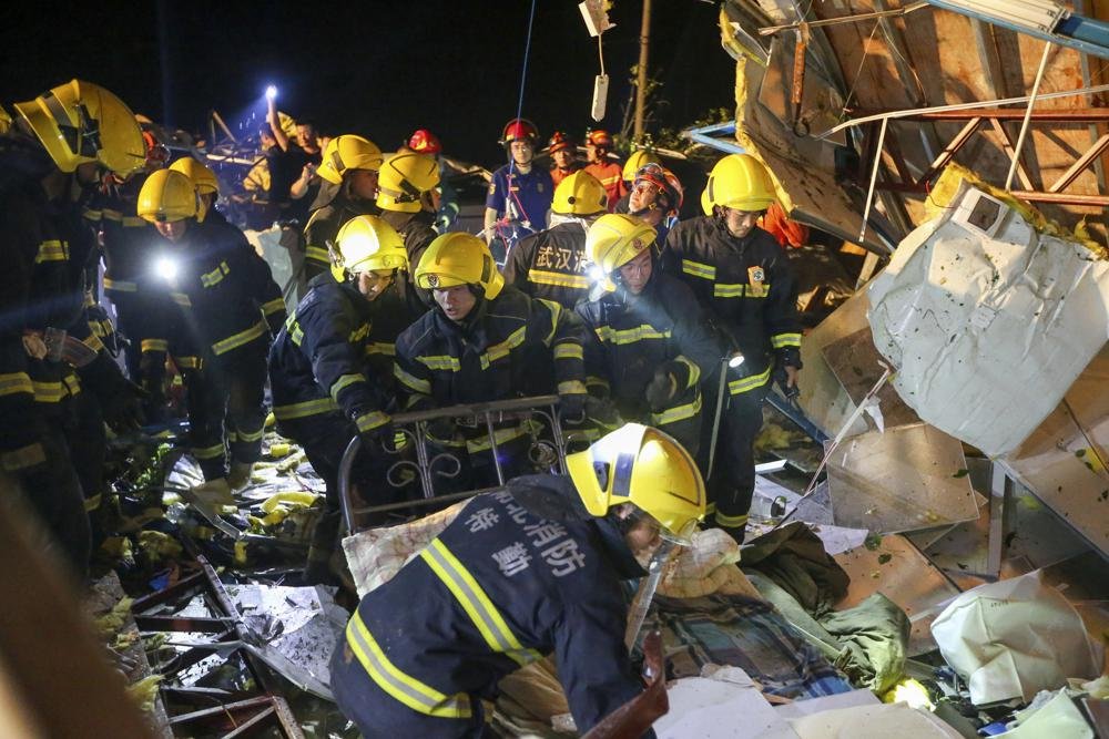 In this photo released by China's Xinhua News Agency, emergency personnel search through the wreckage of buildings destroyed by a reported tornado in Wuhan in central China's Hubei Province, early Saturday, May 15, 2021. Two tornadoes killed several people in central and eastern China and left hundreds of others injured, officials and state media reported Saturday. (Xiong Qi/Xinhua via AP).