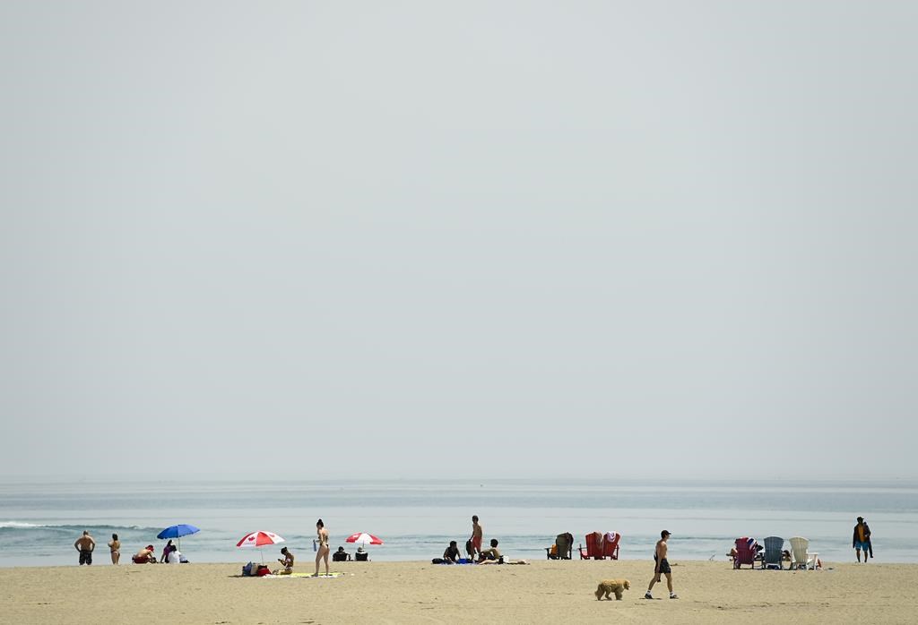 People soak in the sun over looking Lake Ontario on a warm sunny day at Woodbine Beach during the COVID-19 pandemic in Toronto on Tuesday, May 25, 2021. 