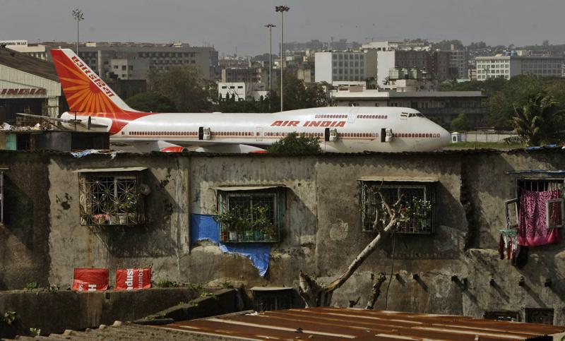 FILE- In this May 25, 2010 file photo, an Air India plane is seen in the background of slums adjoining the the international airport in Mumbai, India. Personal data of an unspecified number of travelers has been comprised in a hack of a company that manages customer data including credit cards, passports and phone numbers for India’s national carrier. The hackers were able to access ten years’ worth of data from the Atlanta-based SITA Passenger Service System that serves Air India, the airline said in a statement Friday. 