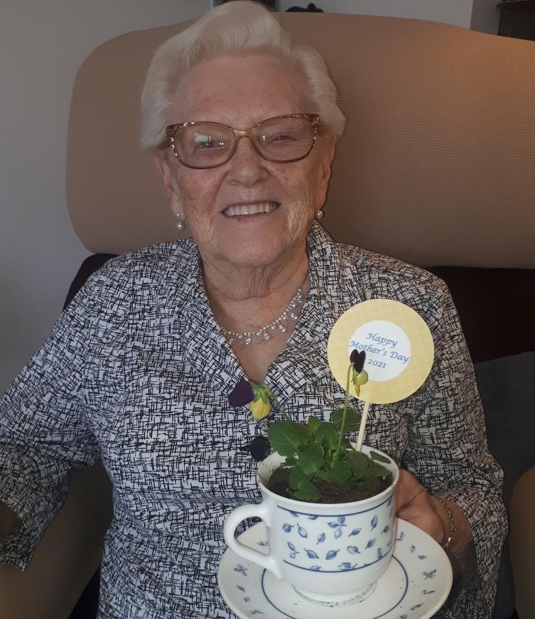 A resident of the Berkeley retirement home in Bedford smiles after receiving her teacup planter on Mother’s Day, May 9, 2021.