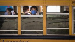 File: A boy wears a mask while riding on the school bus.