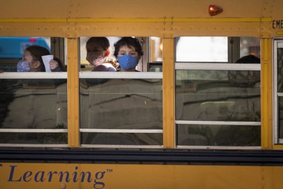 File: A boy wears a mask while riding on the school bus.