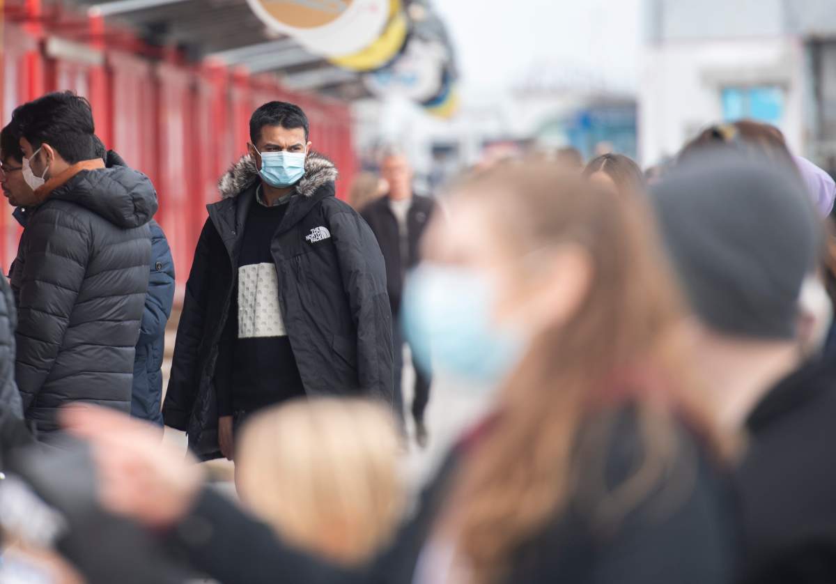 People wear face masks as they browse at an outdoor boutique in the Old Port in Montreal, Sunday, April 4, 2021.