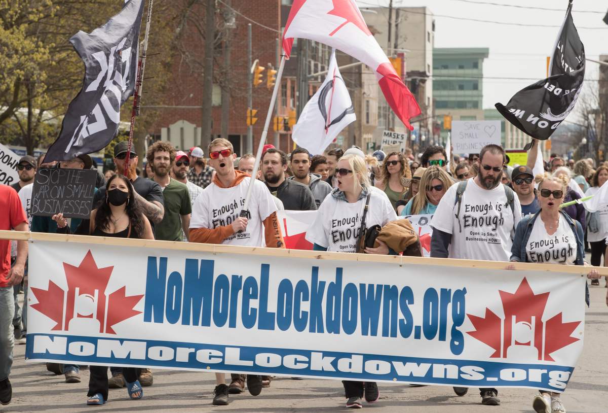 Demonstrators march at a protest against government measures to curb the spread of COVID-19, in Peterborough, Ont., Saturday, April 24, 2021. 