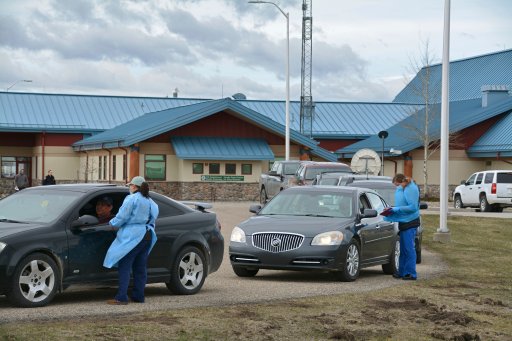 In this Thursday, April 29, 2021, photo, nurses interview patients through their car windows after providing them with COVID-19 vaccines at the Piegan-Carway border crossing after they drove from Canada to Montana to receive excess doses from the Blackfeet tribe, near Babb, Mont.