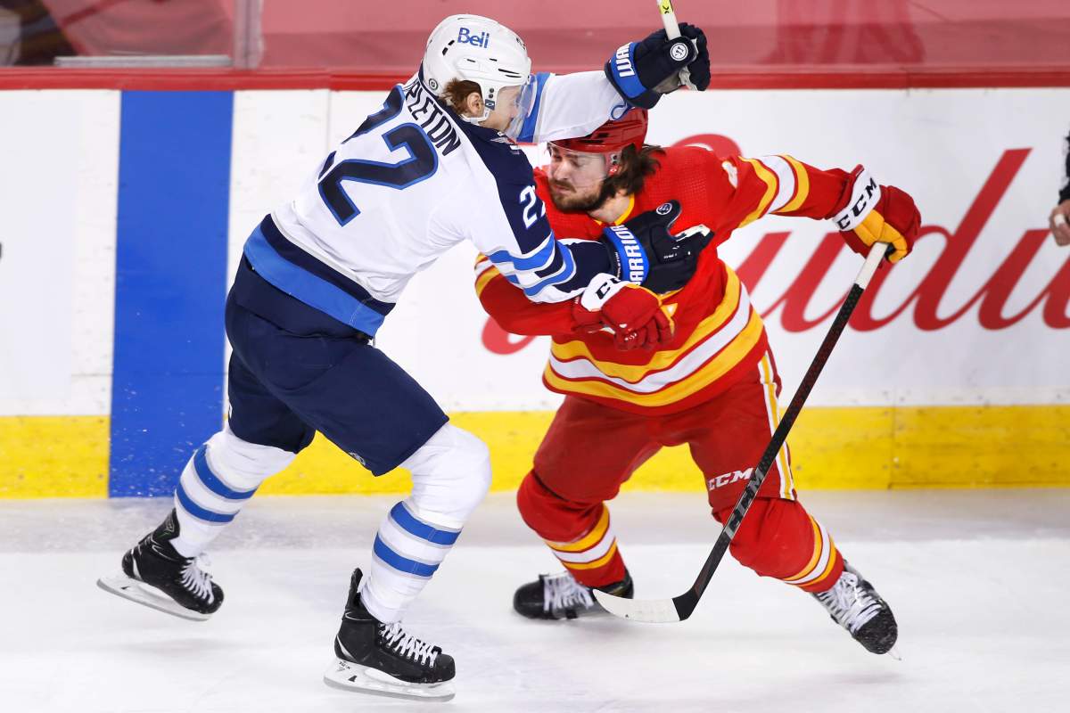 Winnipeg Jets’ Mason Appleton, left, runs into Calgary Flames’ Rasmus Andersson, from Sweden, during second period NHL hockey action in Calgary, Wednesday, May 5, 2021.