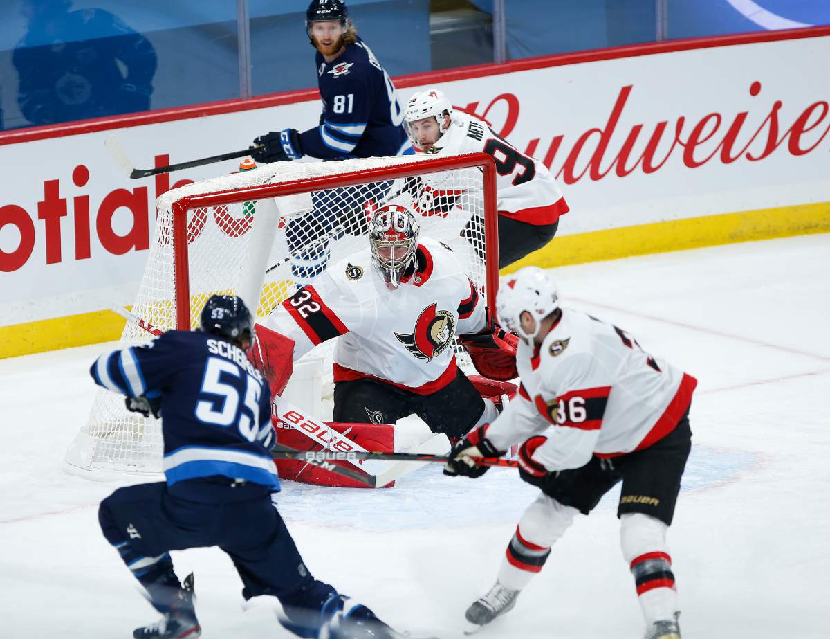Ottawa Senators goaltender Filip Gustafsson (32) saves the shot from Winnipeg Jets’ Mark Scheifele (55) as Colin White (36) defends during first period NHL action in Winnipeg on Saturday, May 8, 2021.