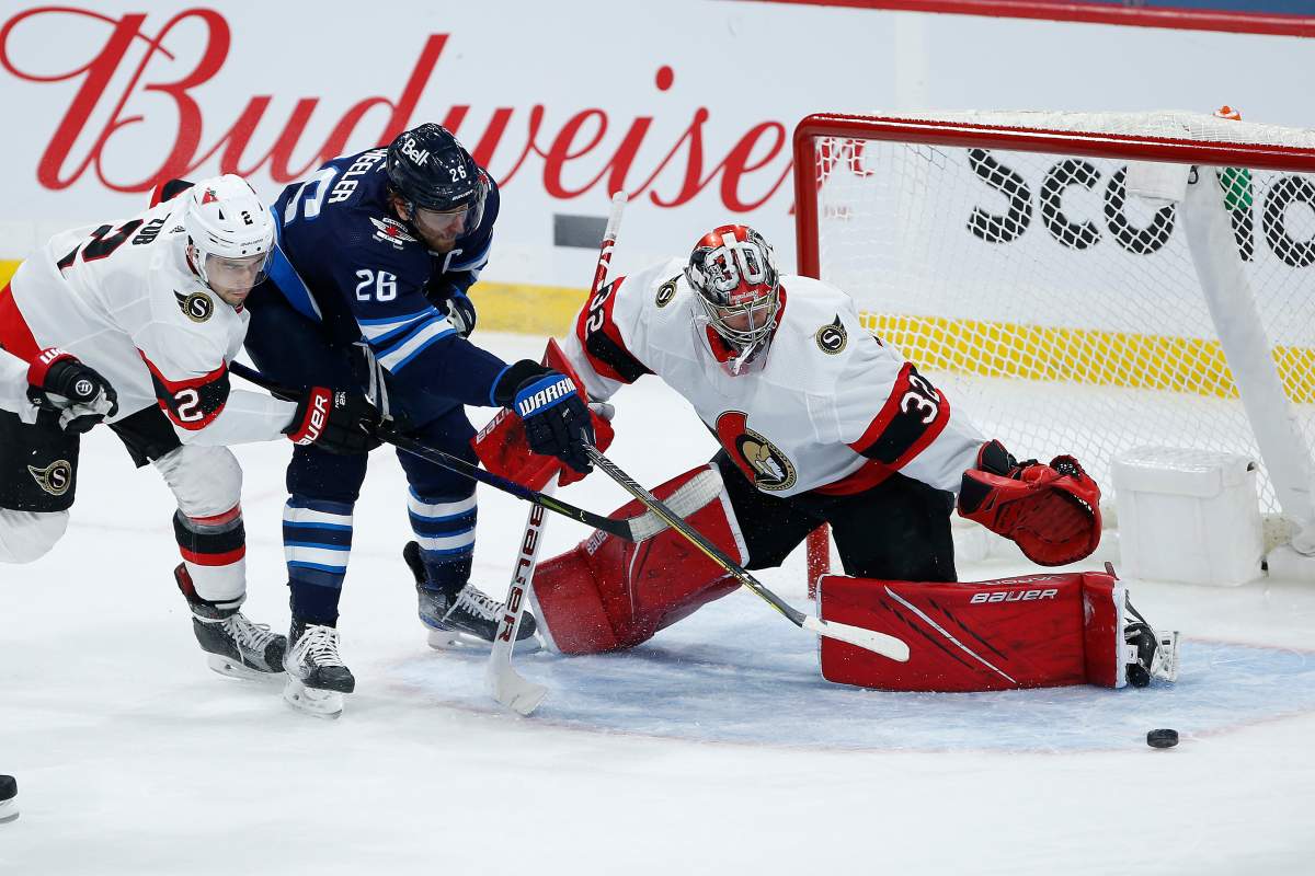 Ottawa Senators goaltender Filip Gustafsson (32) saves the shot by Winnipeg Jets' Blake Wheeler (26) as Artem Zub (2) defends during second period NHL action in Winnipeg on Saturday, May 8, 2021.