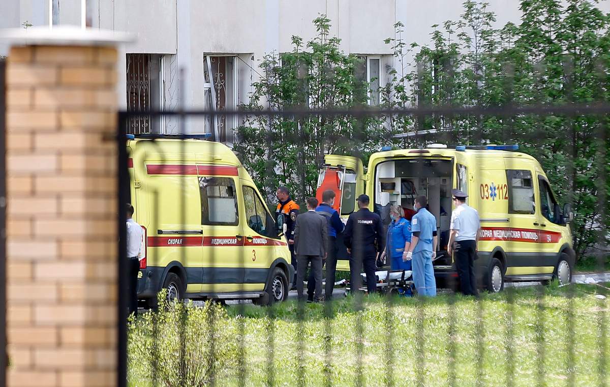 Medics and police prepare to move bodies of students who were killed at a school in a shooting in Kazan, Russia, Tuesday, May 11, 2021.